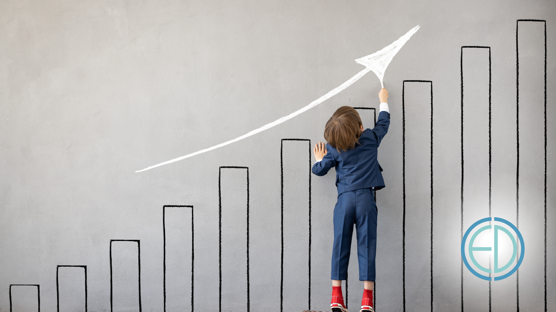 A little boy is drawing an arrow on a graph on a wall.