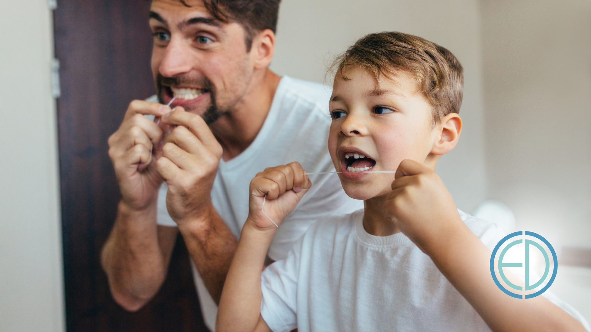 A man and a boy are flossing their teeth in front of a mirror.