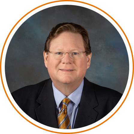 A man wearing glasses and a striped shirt is smiling