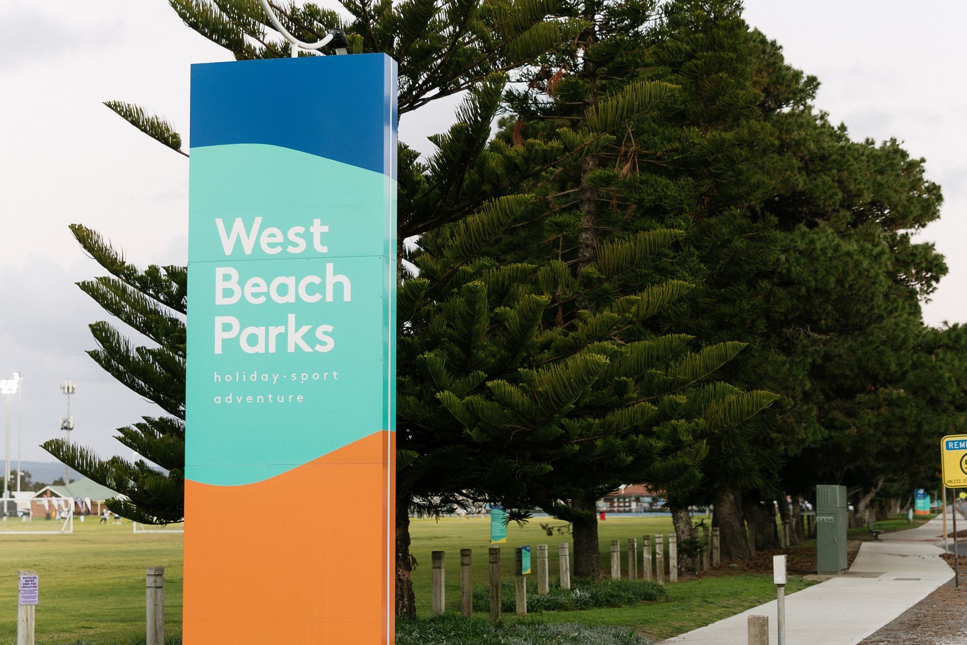 West Beach Parks sign surrounded by trees, near Esplanade Apartments