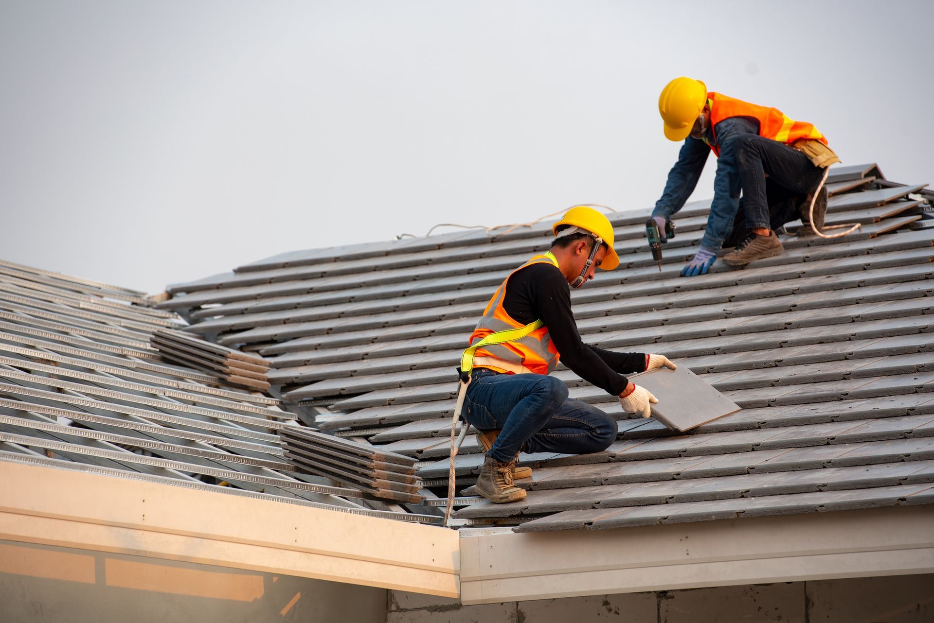 Emergency roofing contractor repairing roof with safety gear.