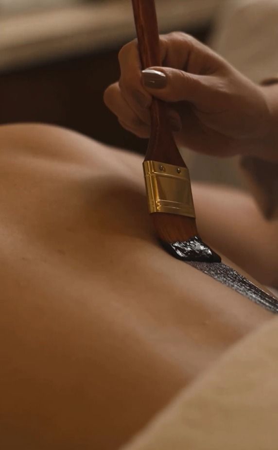 Uma mulher está recebendo uma massagem com uma escova nas costas.