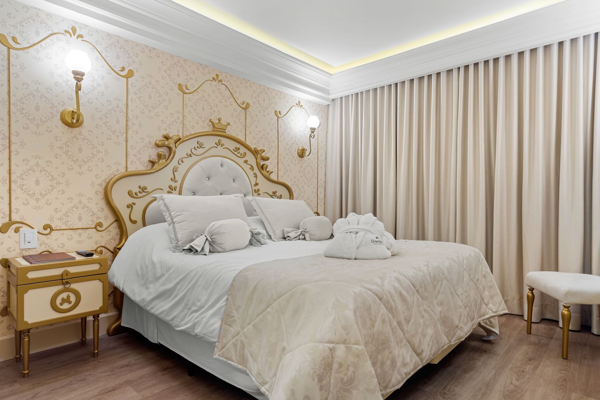 um quarto com cama king size, mesa de cabeceira e cortinas.
