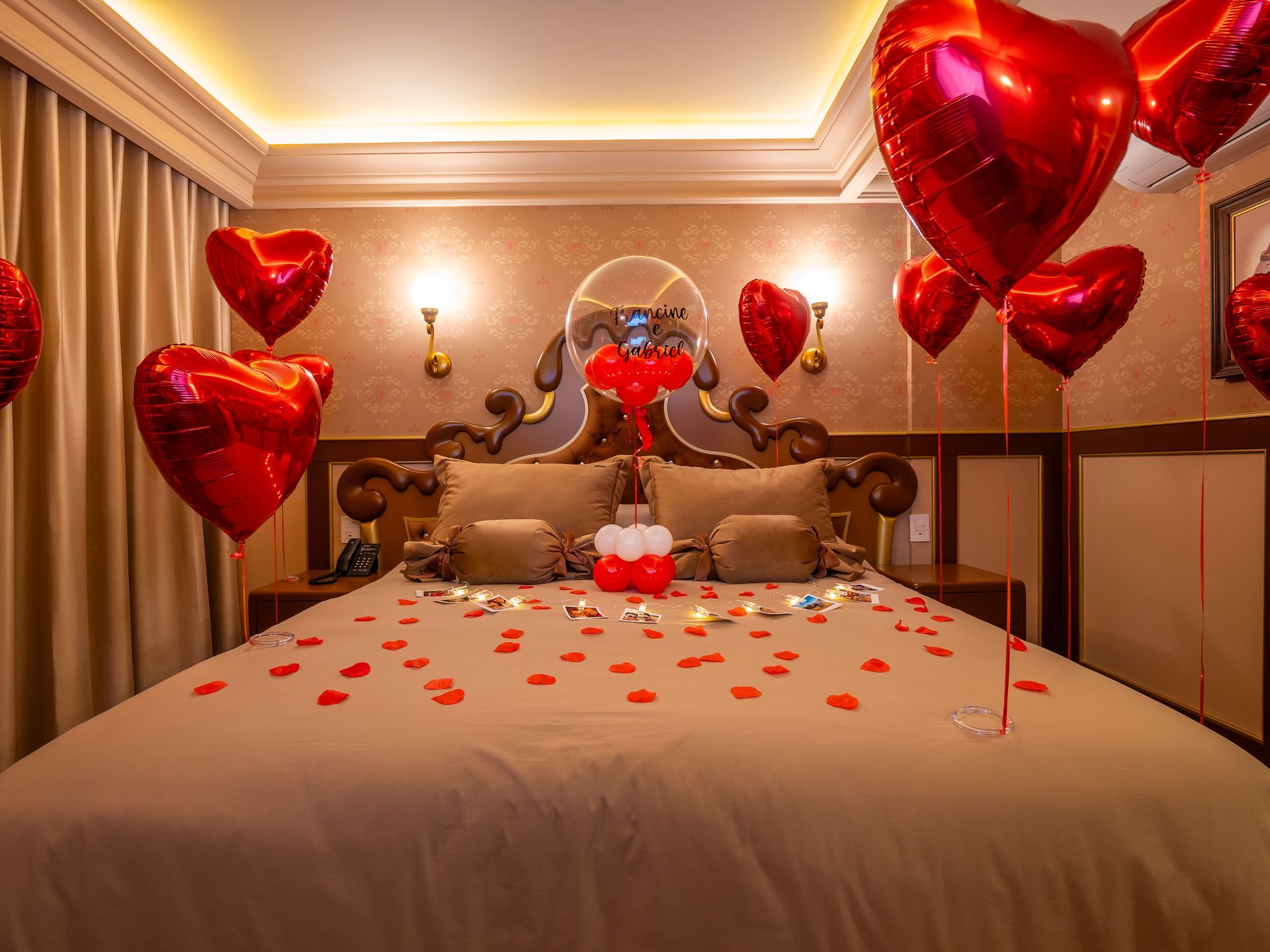 Uma cama decorada para o dia dos namorados com balões, toalhas e comida.