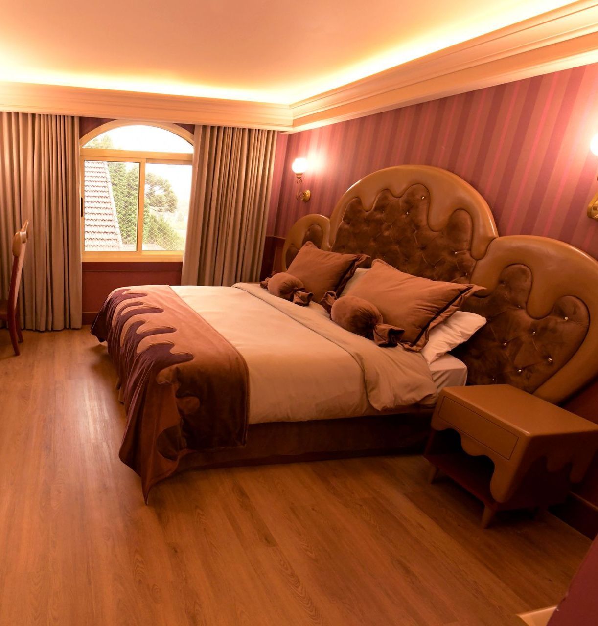 um quarto de hotel com uma cama grande e uma janela