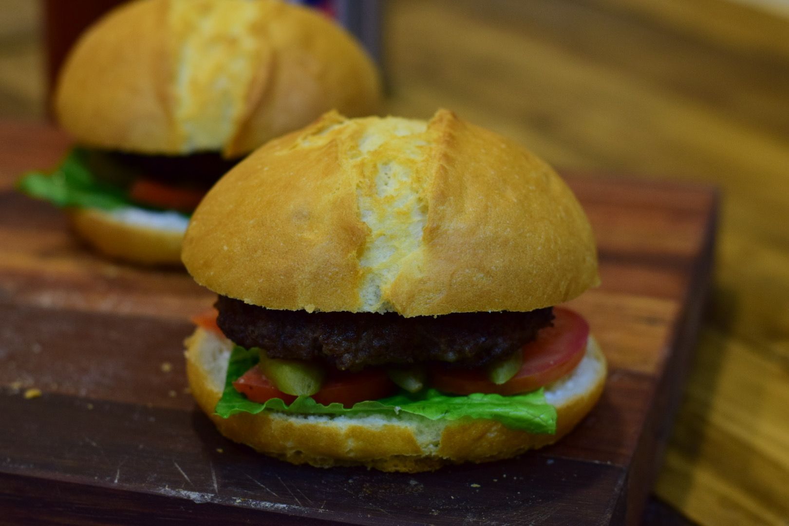 a juicy homemade Persian beef burger with lettuce, tomato, and onion on a toasted bun