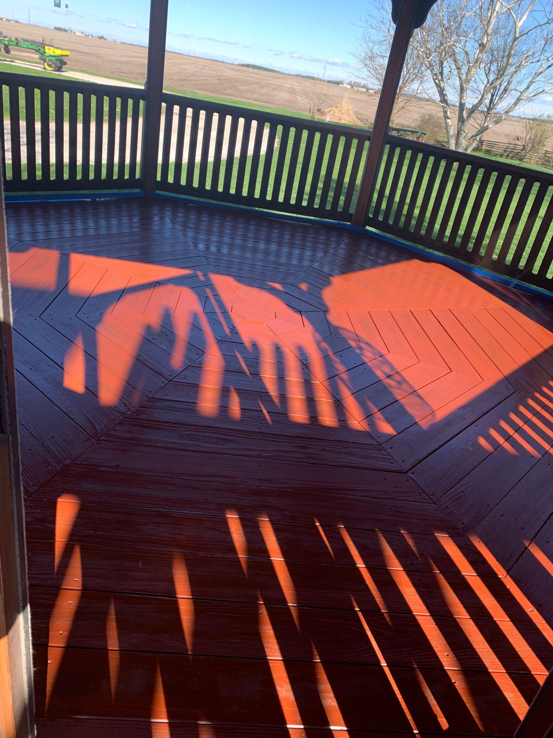 A shadow of a person is cast on a wooden deck