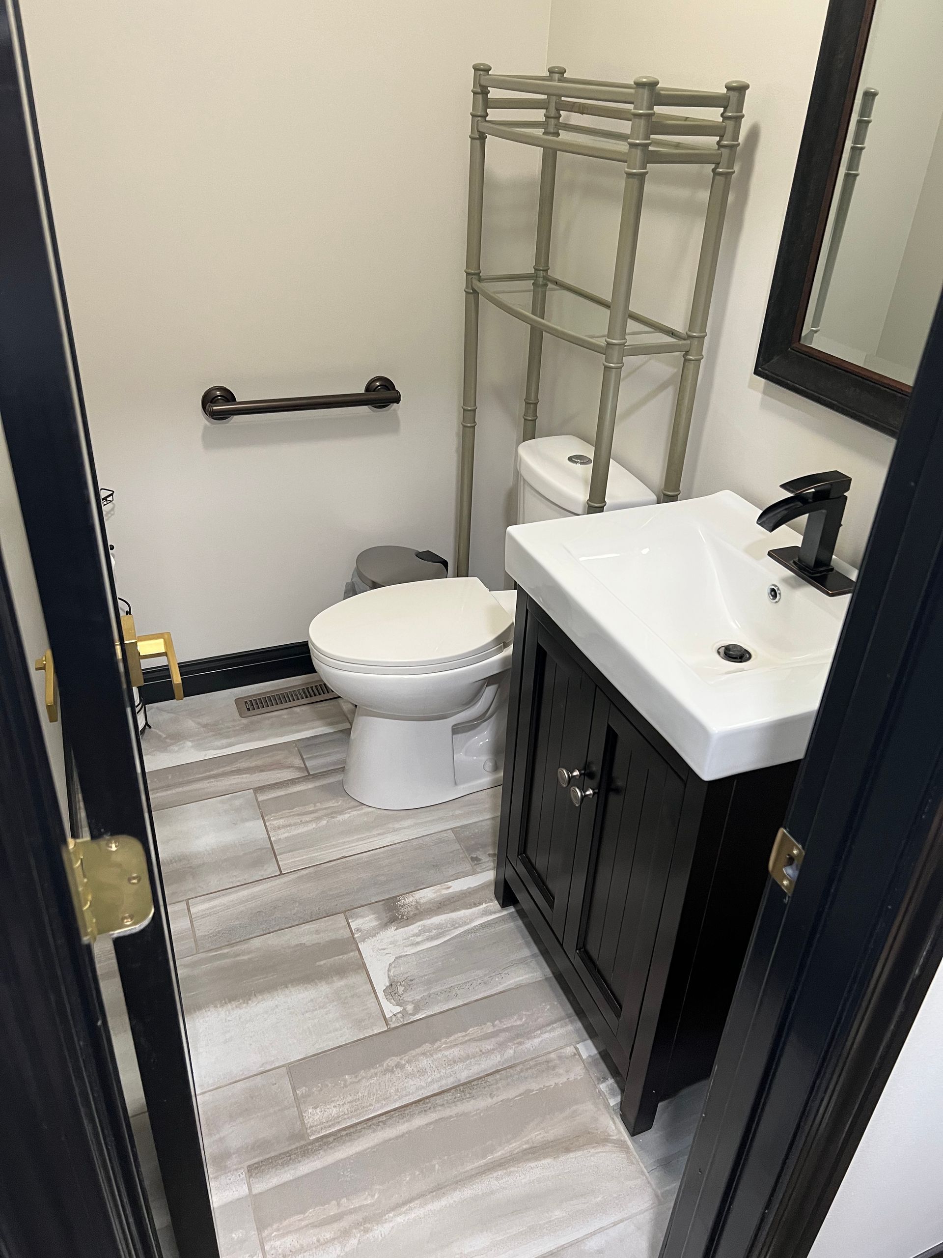 A bathroom with a toilet , sink and mirror.