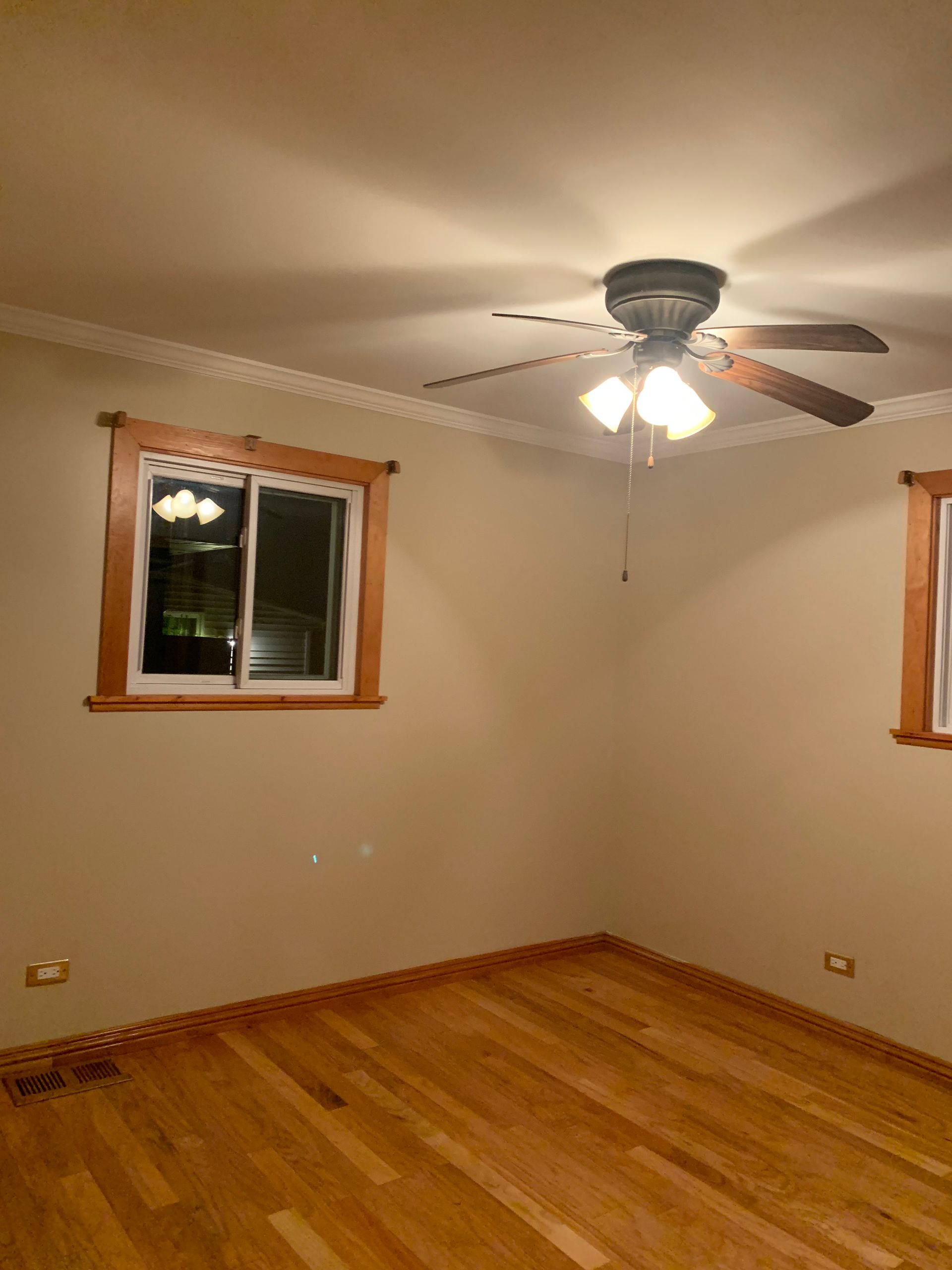An empty room with a ceiling fan and a window