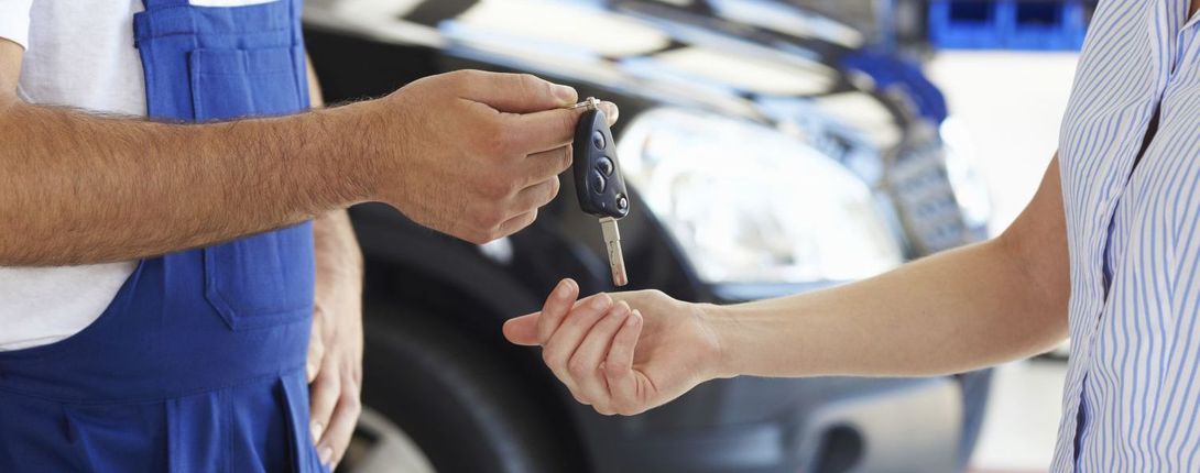 mechanic at automobile boy repair shop at Auckland  returning keys to customer