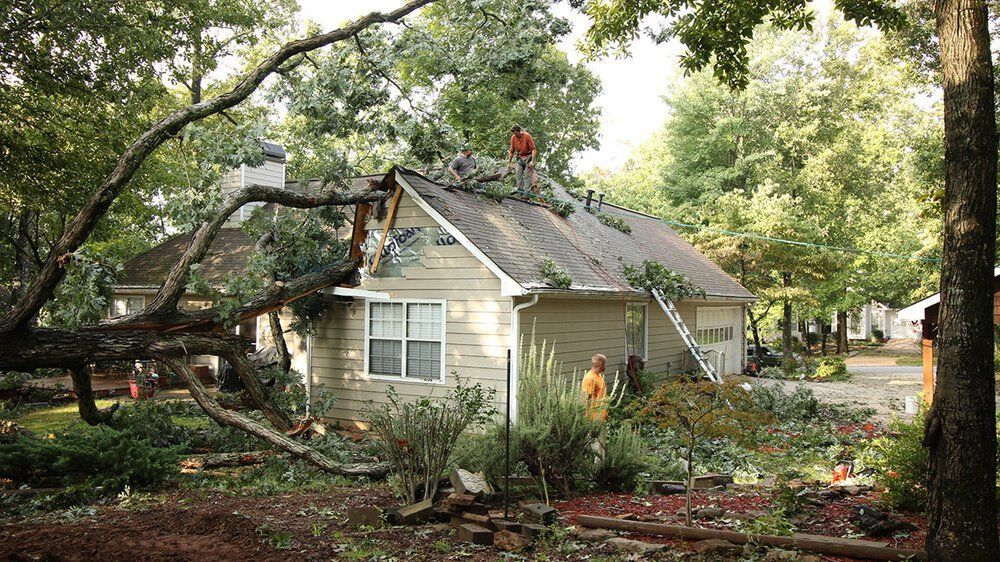 A group of people are working on the roof of a house.