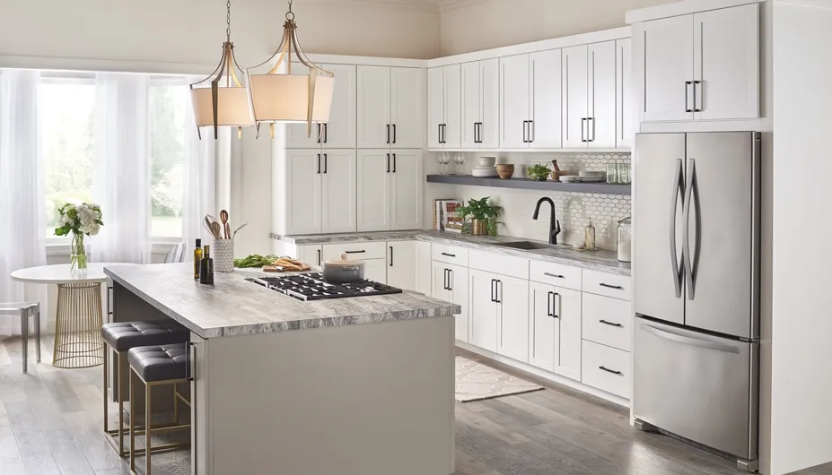 A kitchen with white cabinets , stainless steel appliances , and a large island.