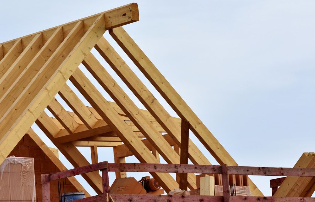 The roof of a house is being built with wooden beams