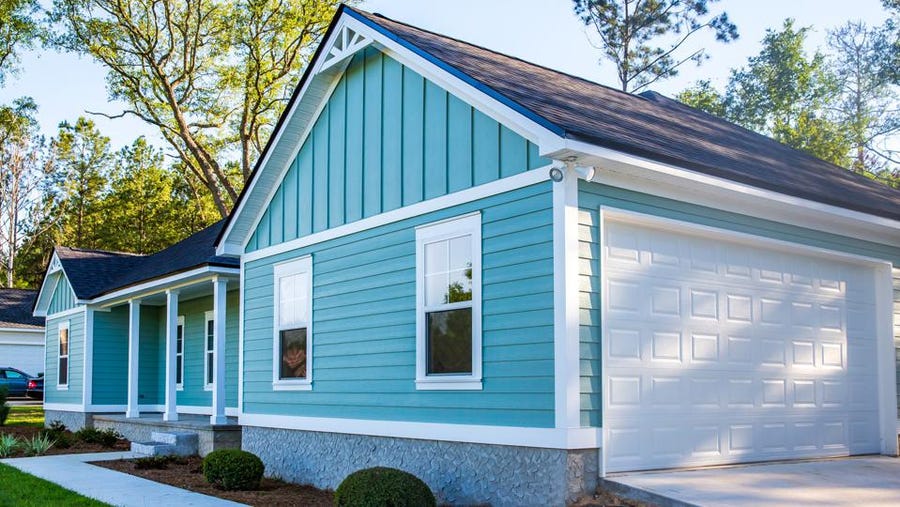 A blue and white house with a garage and porch.