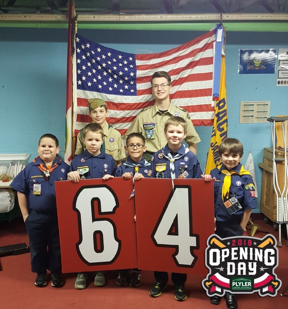A group of boy scouts holding a sign that says 64