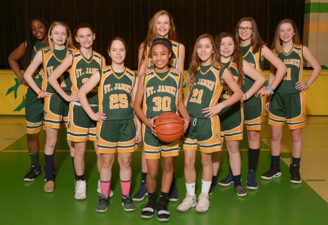 A girl with the number 30 on her jersey is holding a basketball