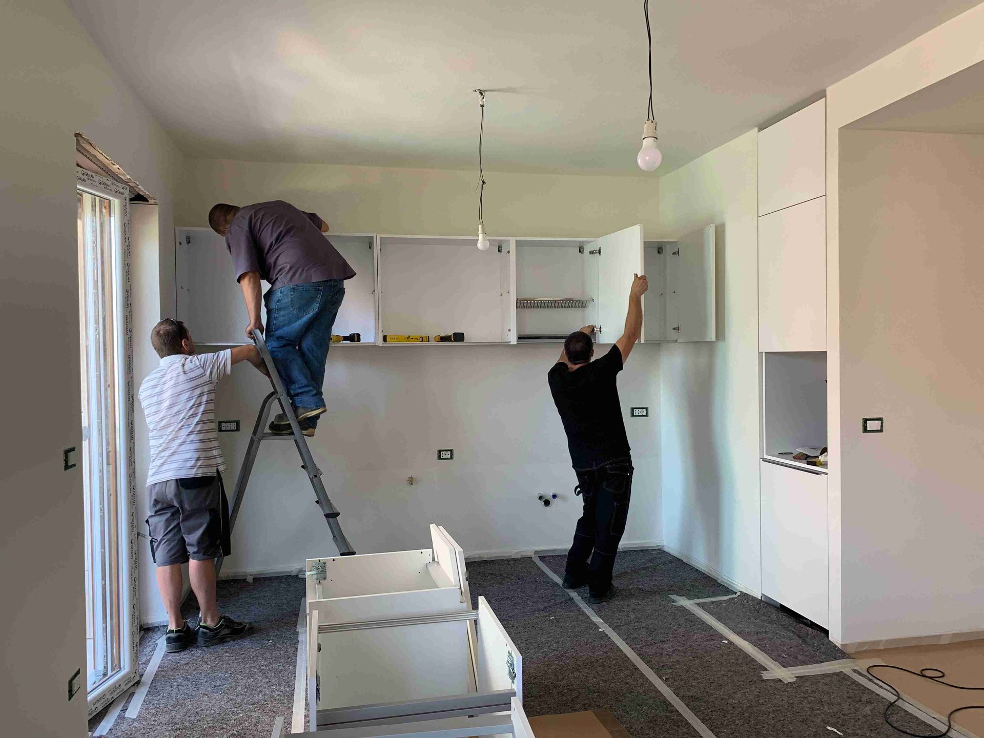 A team installing new cabinets in kitchen