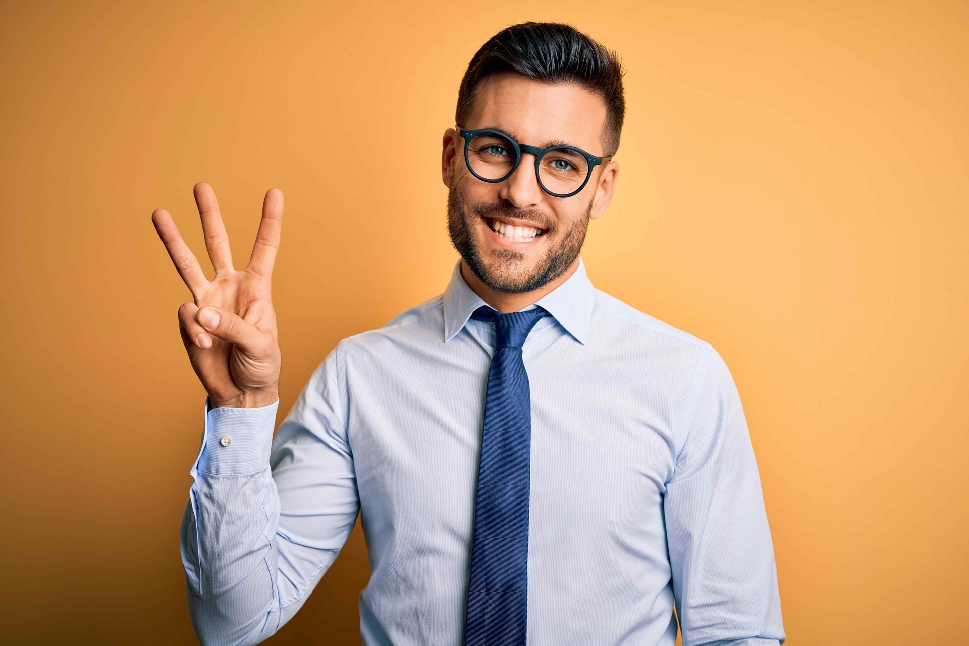 A man holding his hand up to signal three (3) things