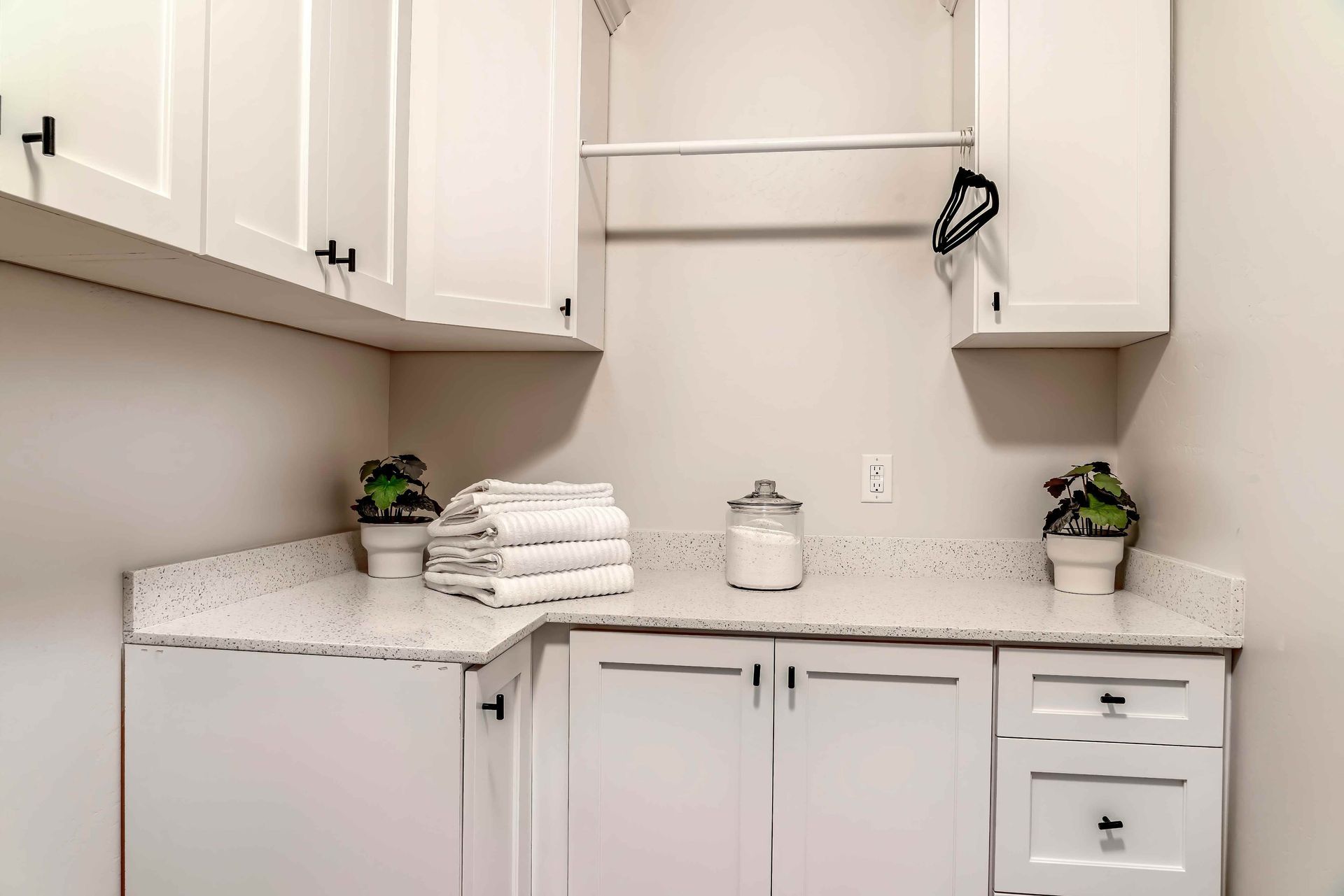 A white bathroom vanity with cabinetry above