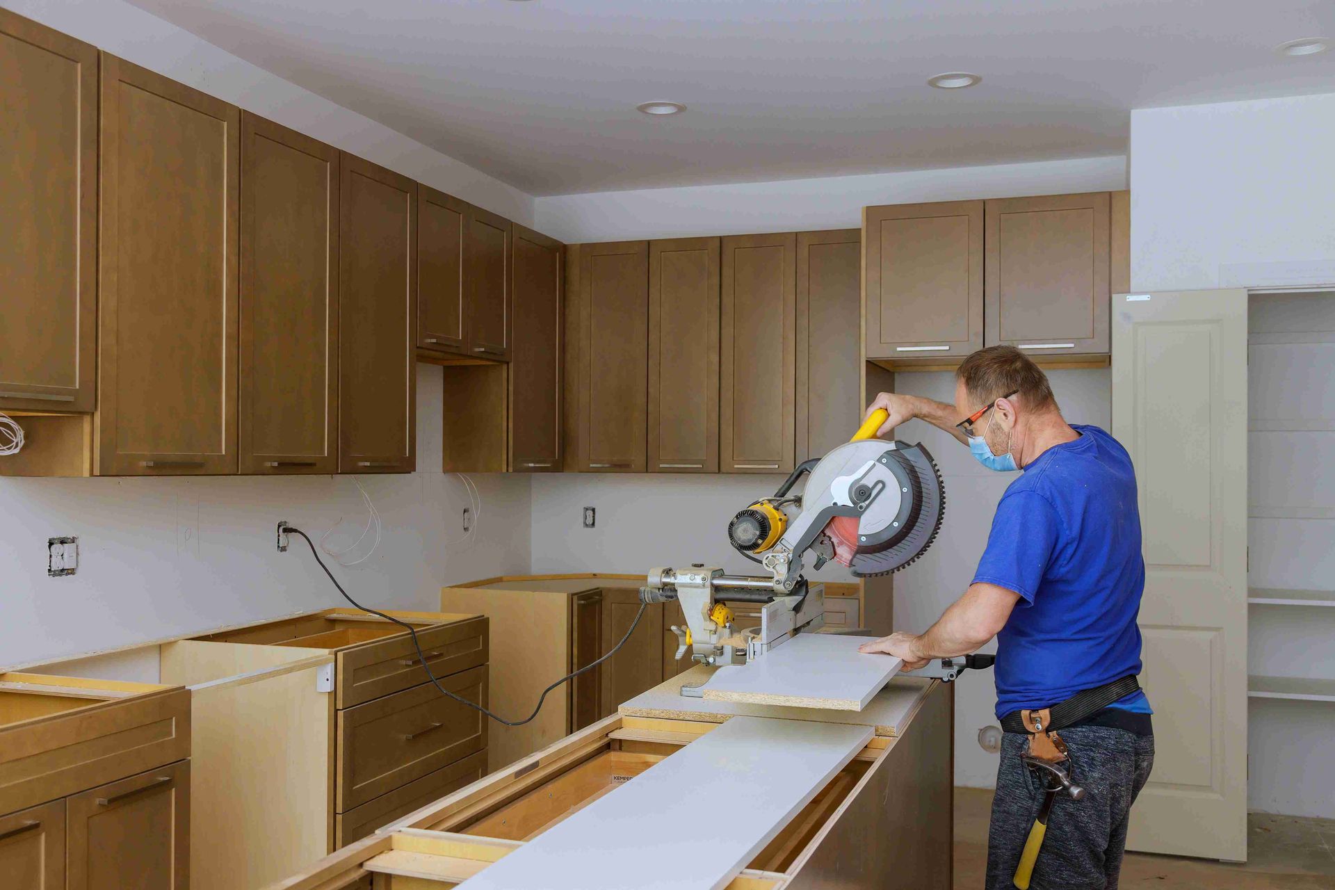 A man cutting and installing Longmont cabinetry
