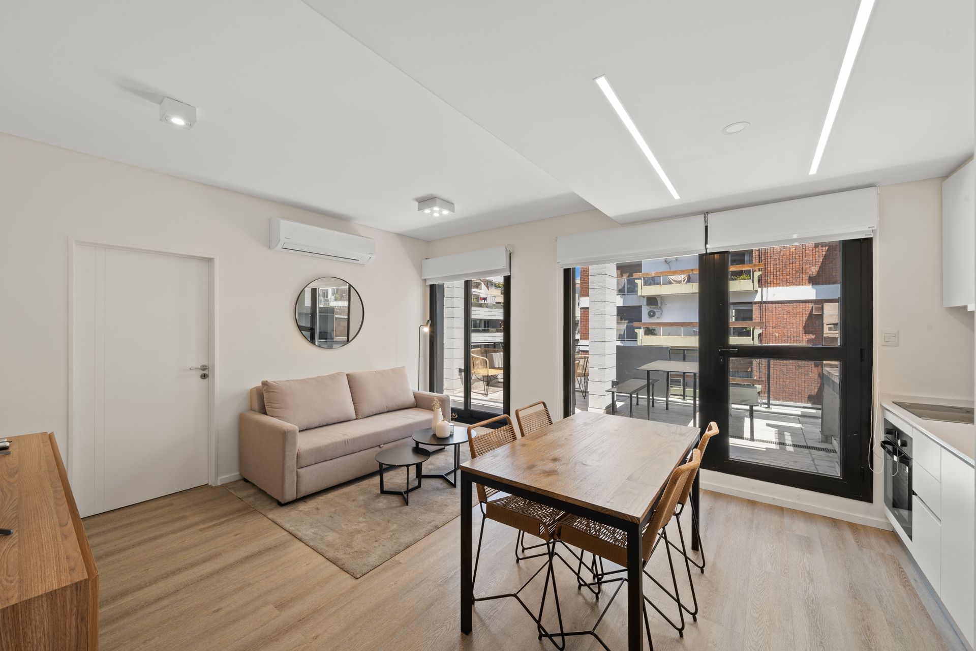 Una sala de estar con sofá, mesa y sillas.