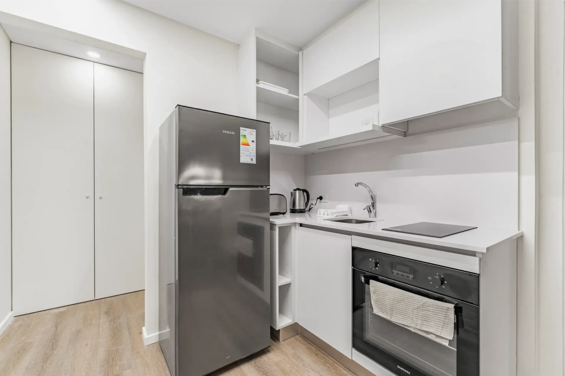 Una cocina con frigorífico, horno, microondas y fregadero.