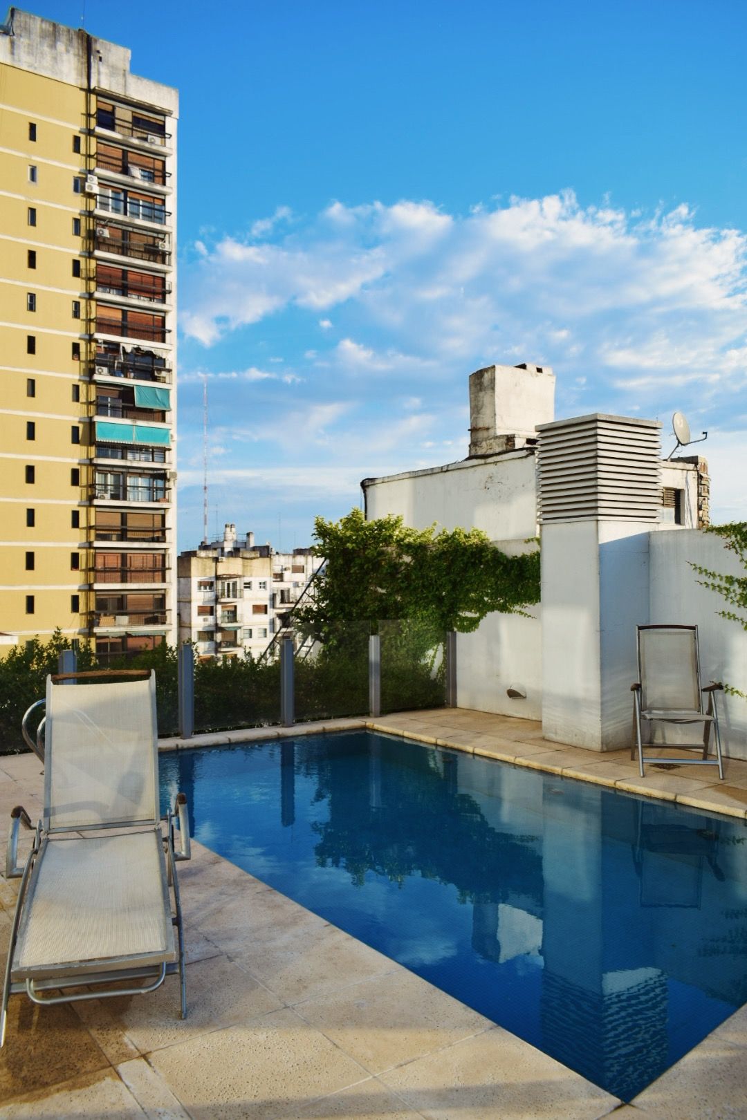 Una gran piscina con un edificio al fondo.