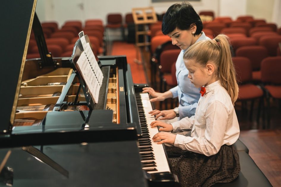 bambina a lezione di pianoforte con insegnante