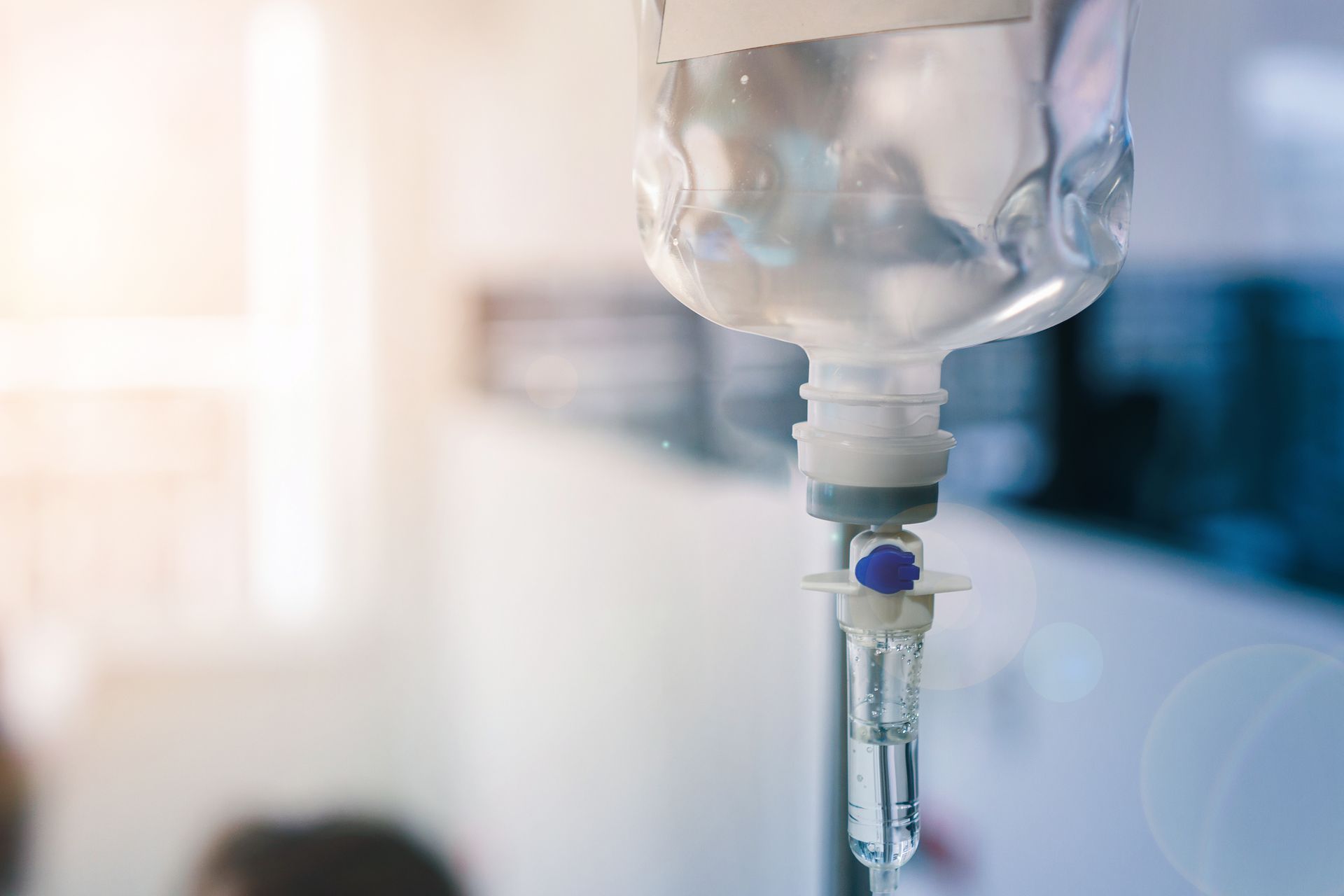 Close-up of a clear IV drip bag and tubing delivering fluid in a medical or hospital setting. Close-up of a clear IV drip bag and tubing delivering fluid in a medical or hospital setting.