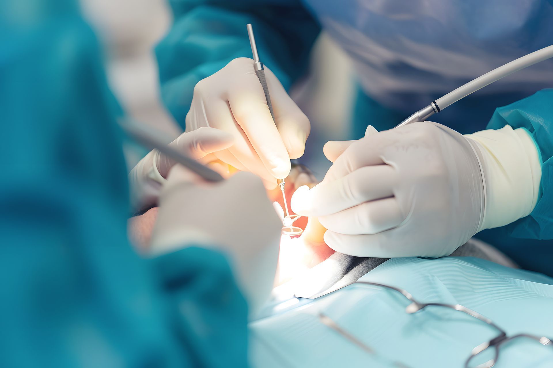 A dentist handles a model of a row of teeth and a dental implant, while sitting in an office.