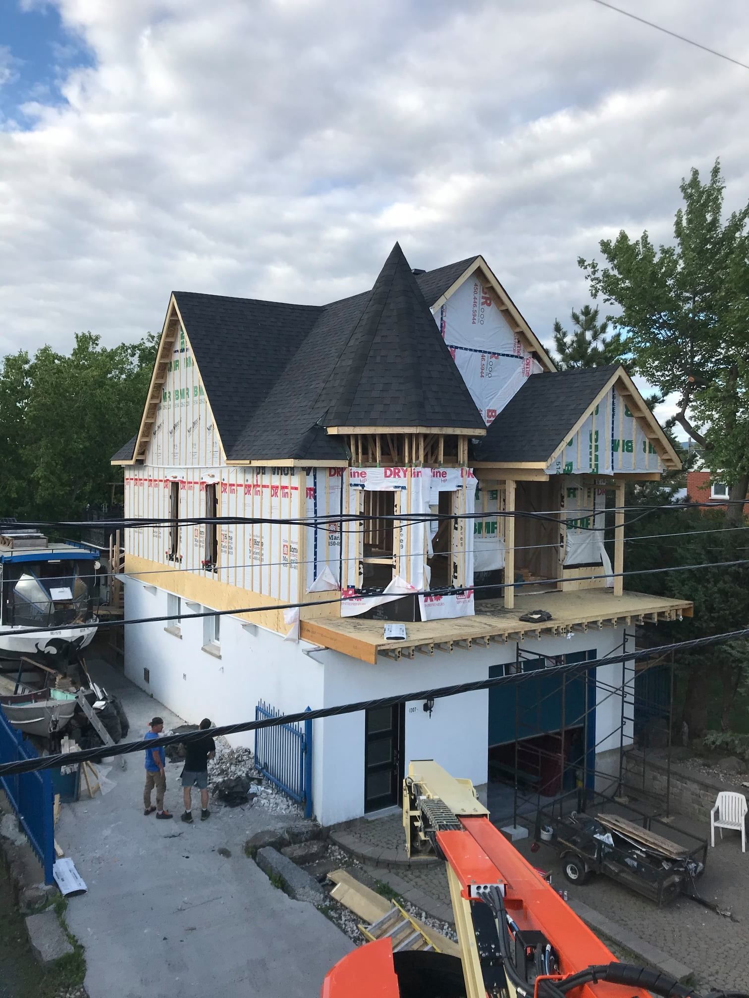 Une maison en construction avec une grue devant elle