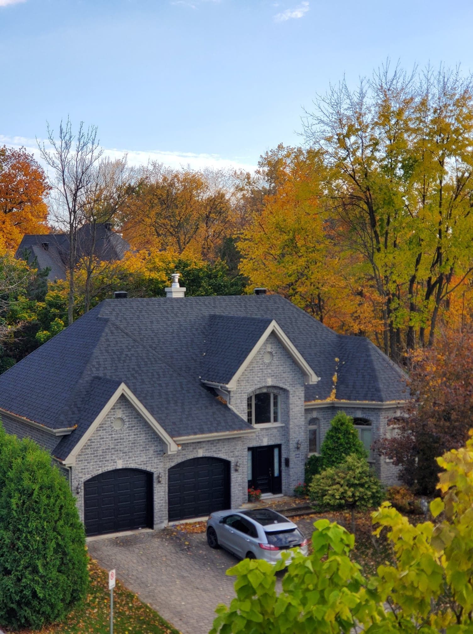 Une grande maison avec une voiture garée devant