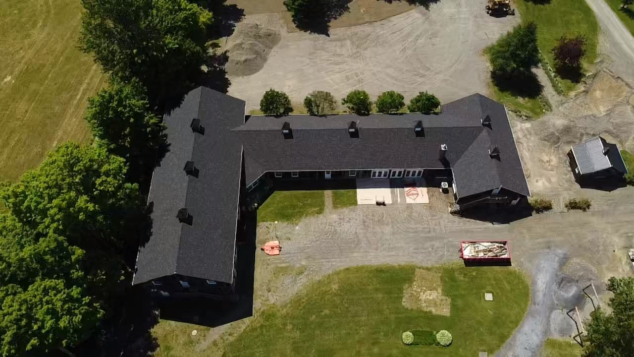 Une vue aérienne d'une grande maison entourée d'arbres et d'herbe.