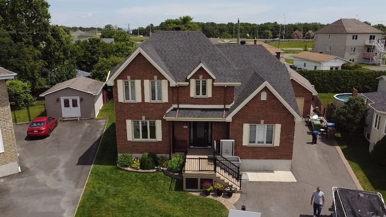 Une vue aérienne d'une grande maison en briques dans un quartier résidentiel.