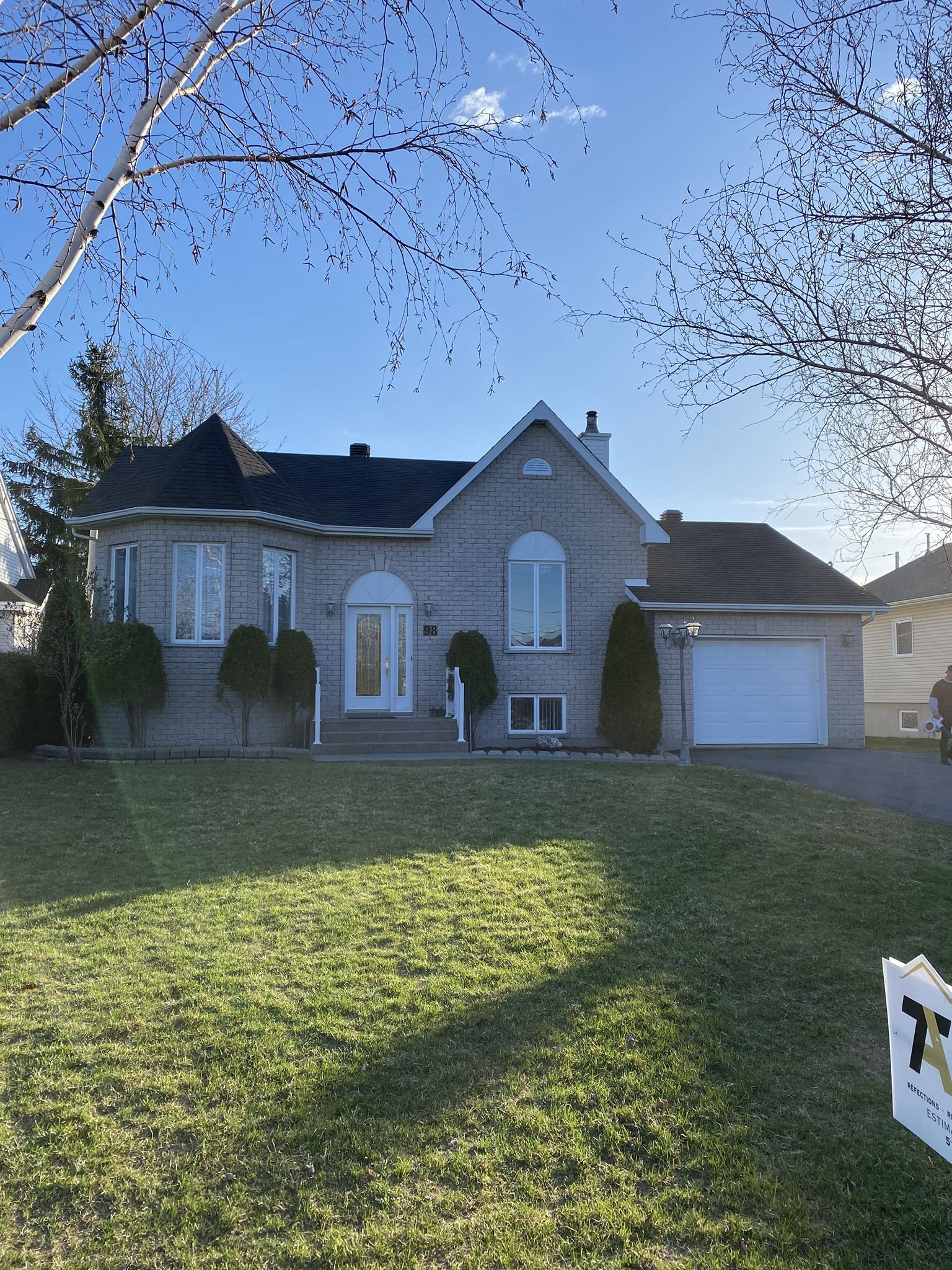 Une grande maison en briques avec une grande pelouse devant.