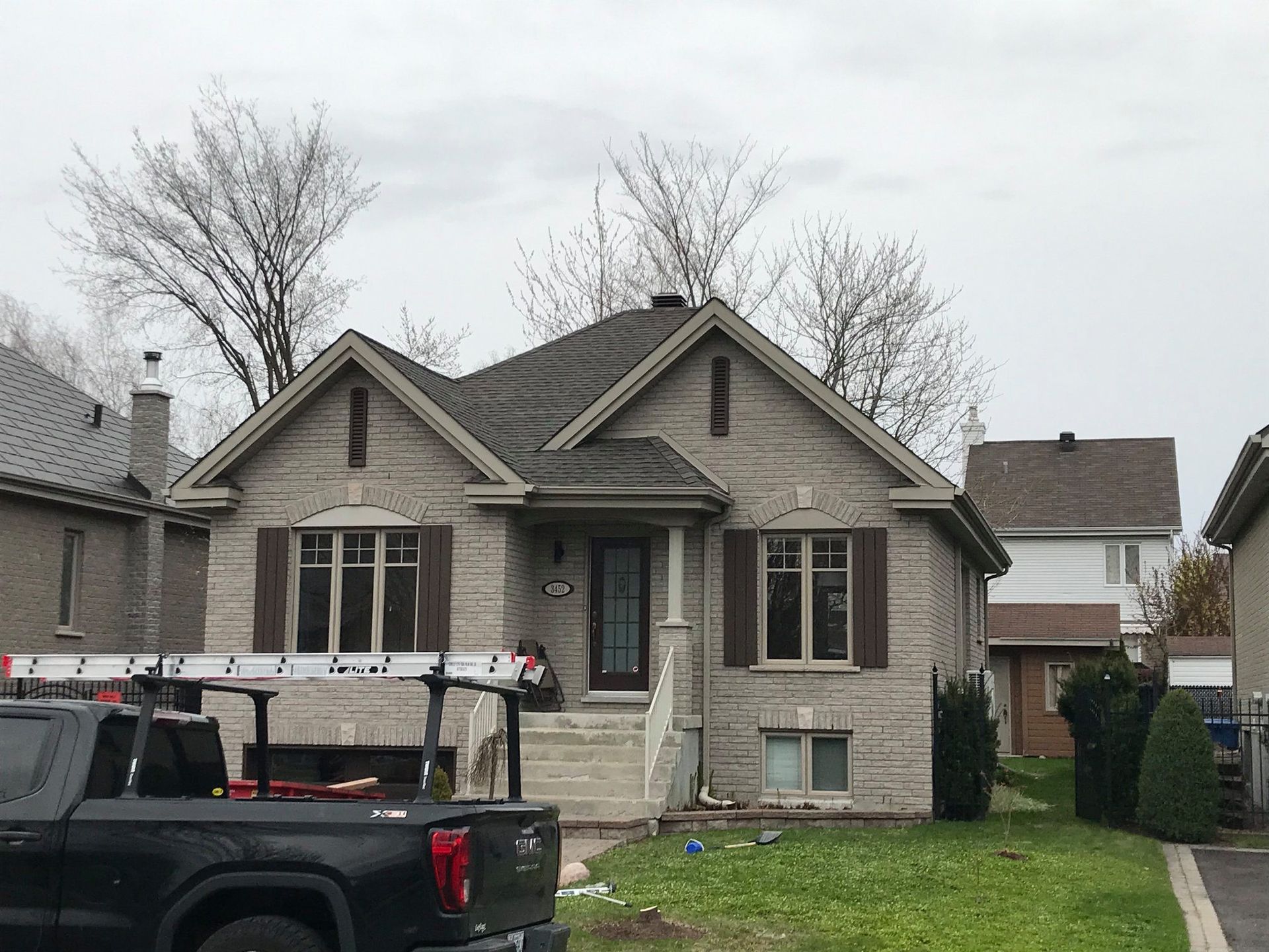 Un camion est garé devant une maison en briques.