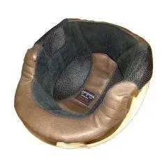 Vista interna di un casco da motociclista d'epoca che mostra l'imbottitura in pelle color cuoio e la fodera in tessuto scuro con una piccola etichetta.