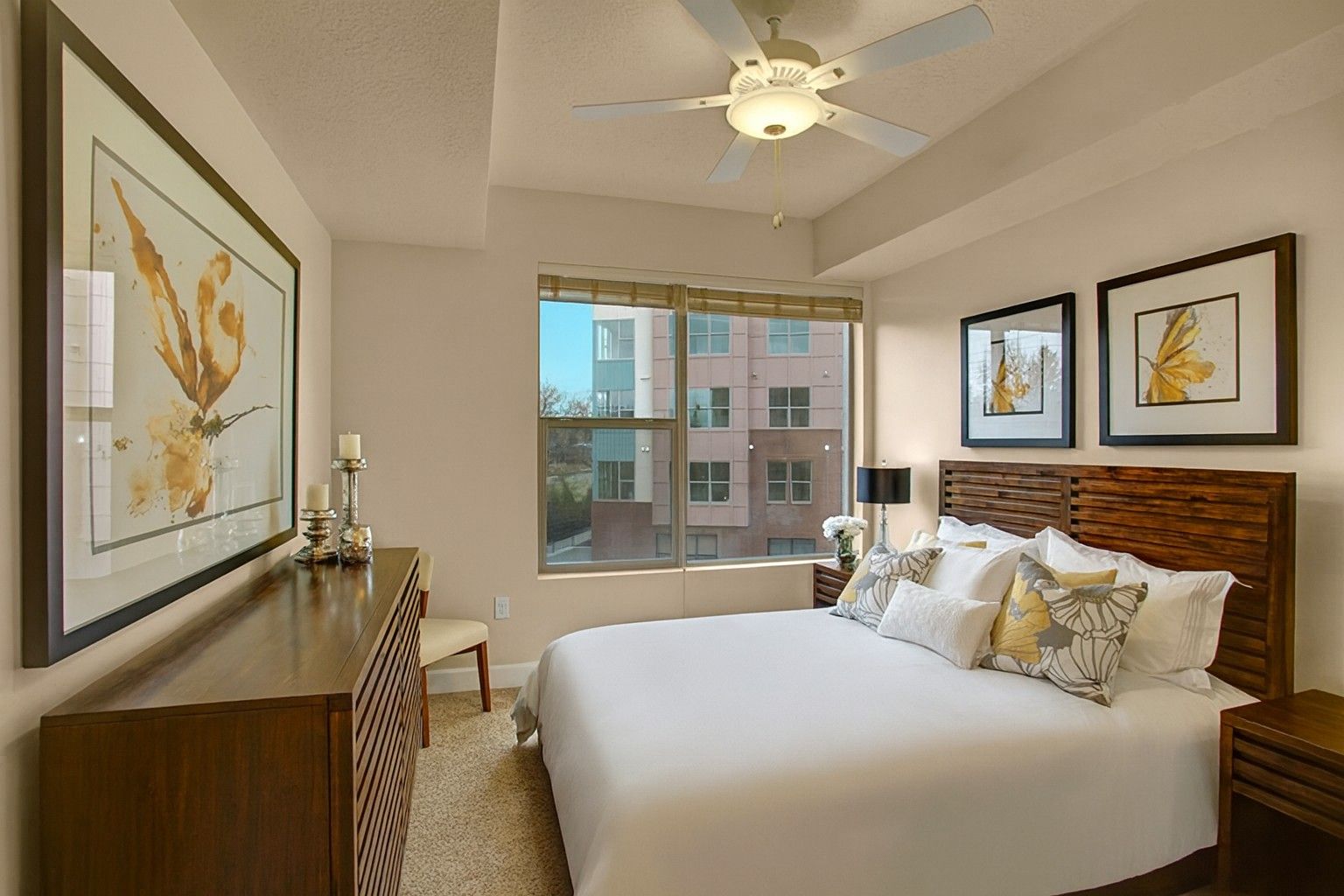 A bedroom with a large bed and a ceiling fan