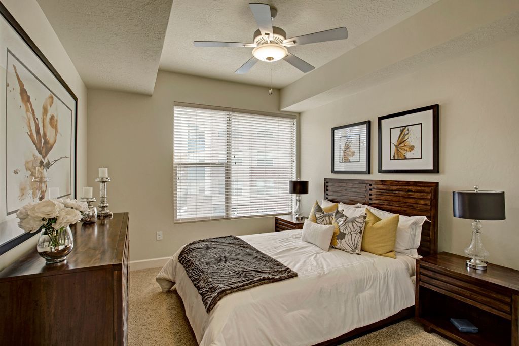 A bedroom with a large bed and a ceiling fan