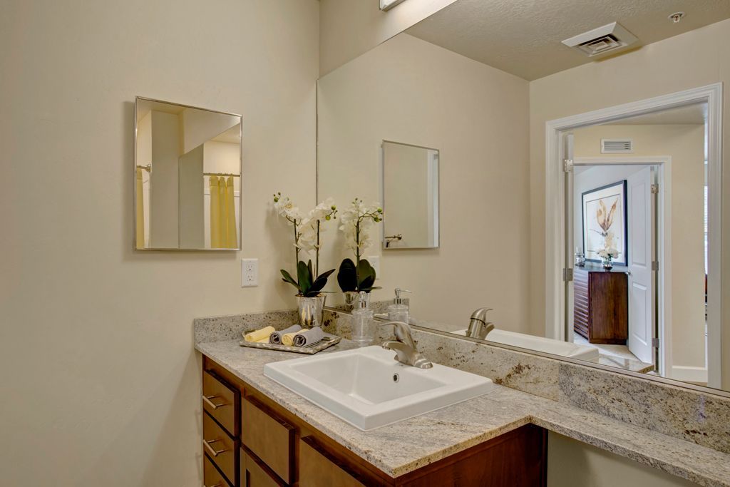 A bathroom with a sink and two mirrors.