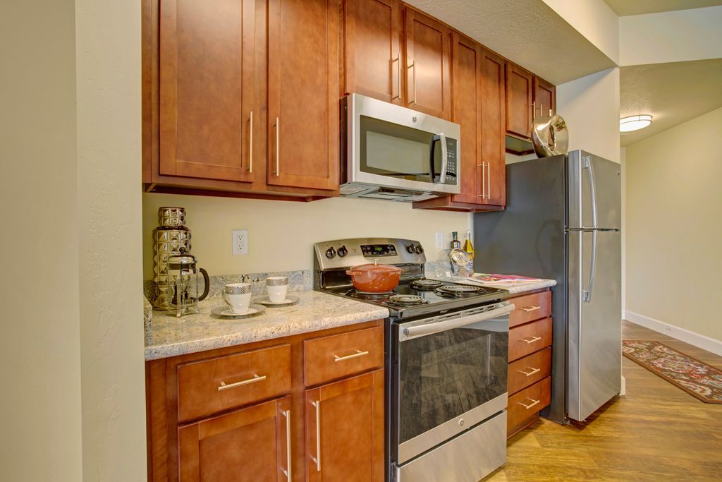 A kitchen with stainless steel appliances and wooden cabinets