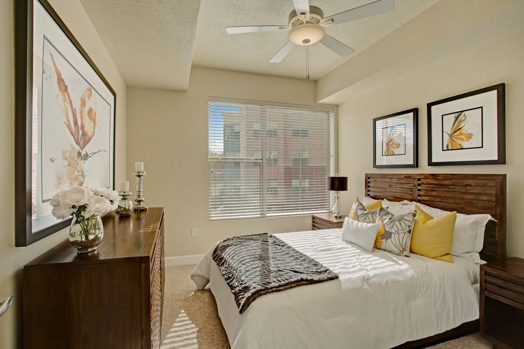 A bedroom with a large bed and a ceiling fan
