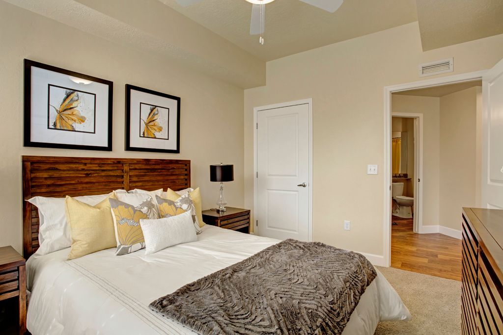 A bedroom with a large bed and a ceiling fan.