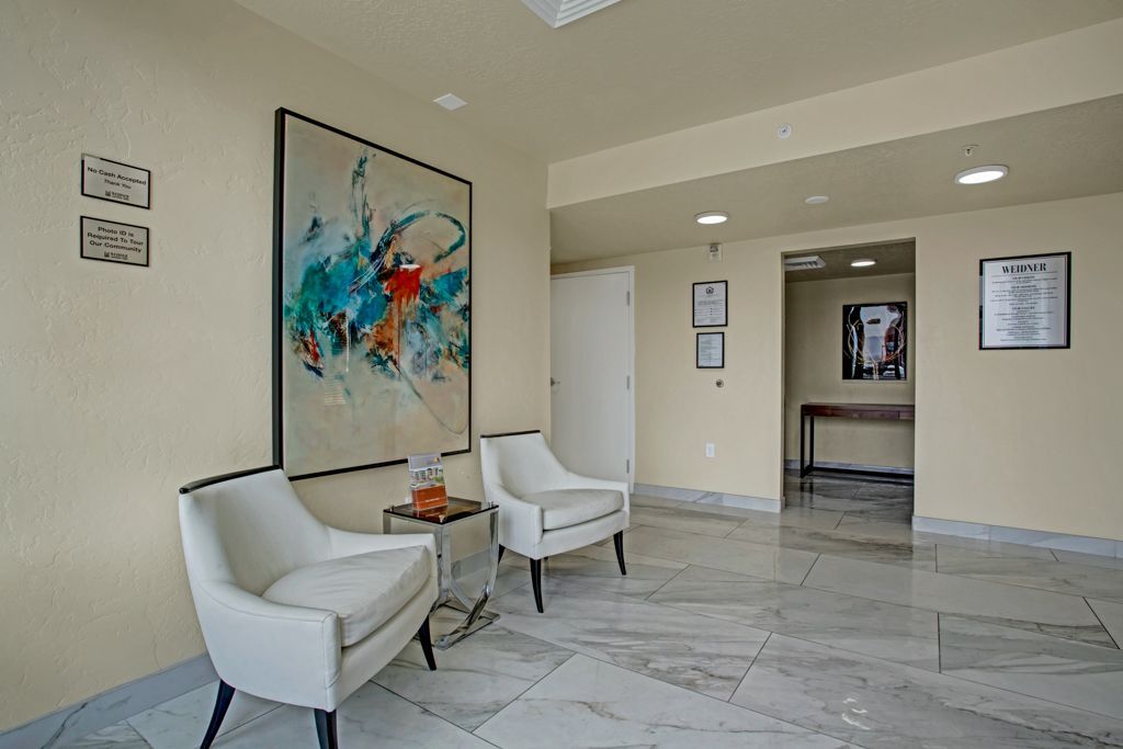 A living room with two chairs and a painting on the wall