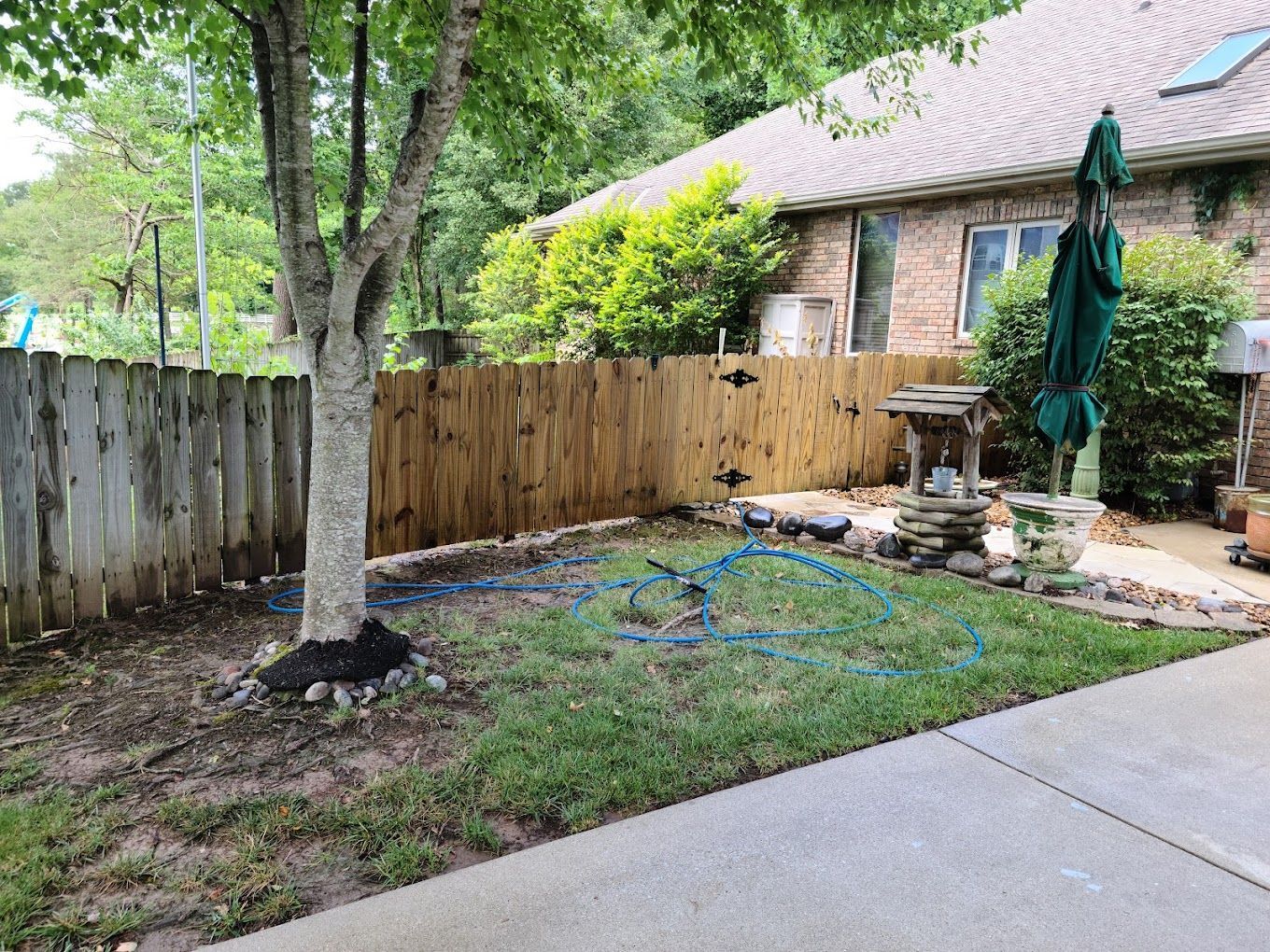 There is a wooden fence in the backyard of a house.