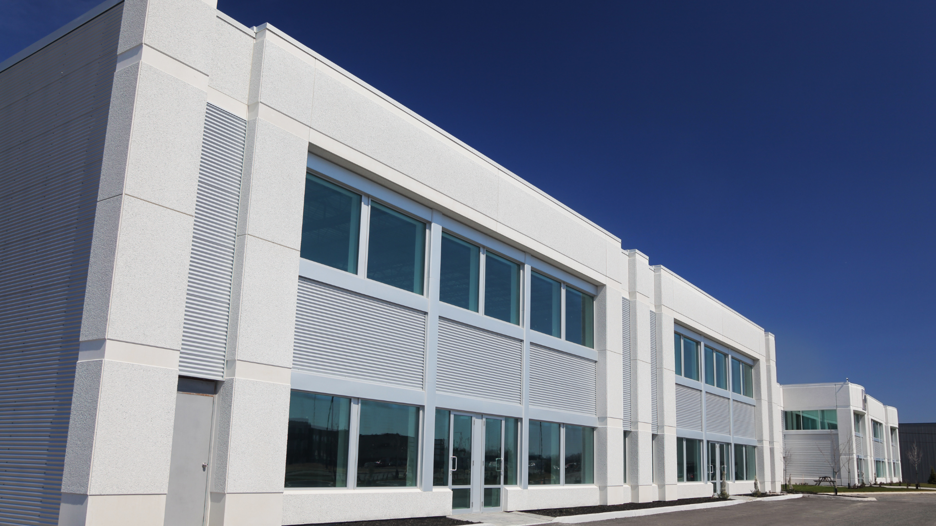 A large white building with lots of windows against a blue sky