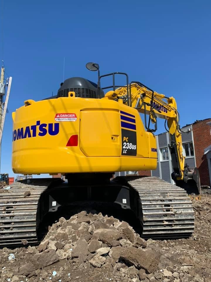 Une excavatrice Komatsu jaune est posée sur un tas de terre
