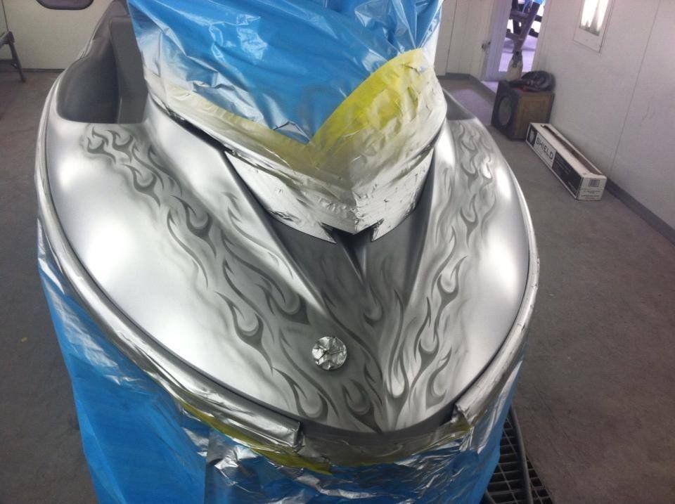A silver jet ski with flames painted on it