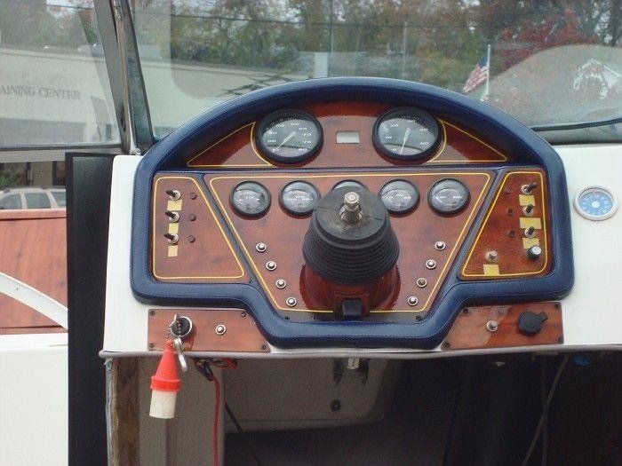 The dashboard of a boat with a steering wheel