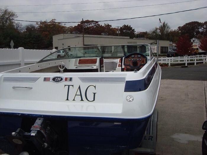 A white and blue boat with the word tag on the back